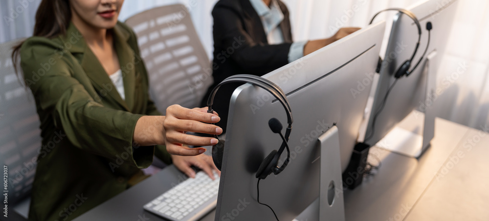 Aufkleber panorama focus hand holding headset on call center workspace desk with blur background of operator t