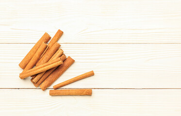 Cinnamon sticks on light wooden background