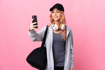 Teenager sport woman with sport bag over isolated background making a selfie