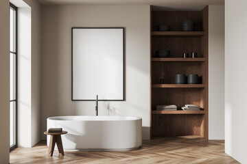 Fototapeta na wymiar Beige bathroom interior with tub, shelves and poster