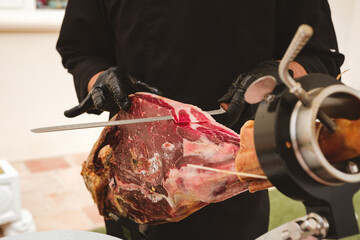 Professional ham carver cutting cured ham slices. Spanish iberian ham.
