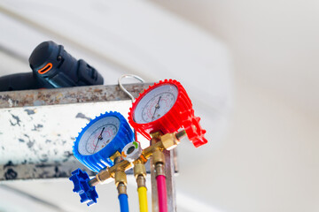 HVAC service technician using manifold gauge to check refrigerant, Air Conditioning Repair - obrazy, fototapety, plakaty