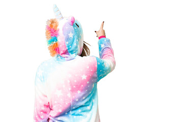 Young girl with unicorn pajamas over isolated chroma key background pointing back with the index finger