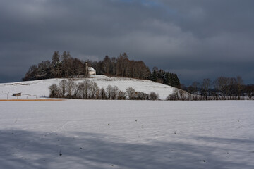 Dunkle Schneewolken über der Kapelle