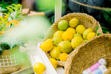 Fresh lemons in wicker basket with flowers