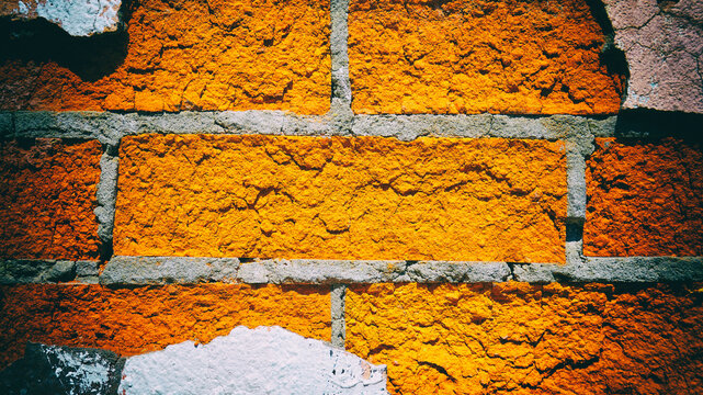 Red brick wall with pieces of peeling plaster. Vintage camera filter added to image