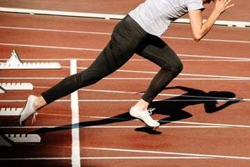 woman sprinter start running from starting blocks 100 metres race in summer athletics championships