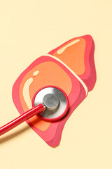 Red paper liver with stethoscope on orange background