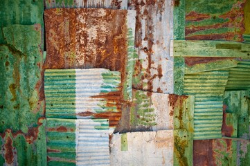 Shot of the flag of Norfolk Island painted on rusty overlapping corrugated iron sheets