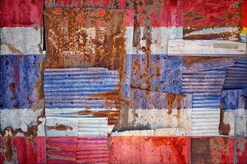 Flag of Thailand painted onto rusty corrugated iron sheets overlapping to form a wall or fence