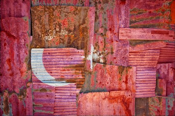Flag of Turkey painted onto rusty corrugated iron sheets overlapping to form a wall or fence