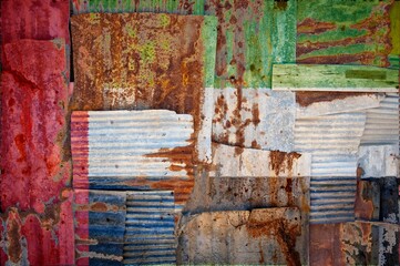 Flag of United Arab Emirates painted onto rusty corrugated iron sheets overlapping to form a wall