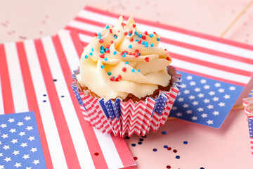 Tasty patriotic cupcakes with flags of USA on pink background. American Independence Day