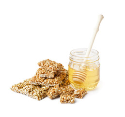 Honey with tasty kozinaki of sunflower seeds on white background