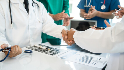 Shaking hands of International doctor team meeting hospital medical staff.