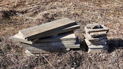 雑草に覆われた冬の野原に置かれたコンクリートブロック