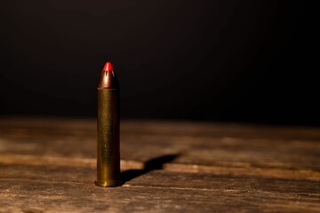 45-70 rifle bullet against black background on wooden crate