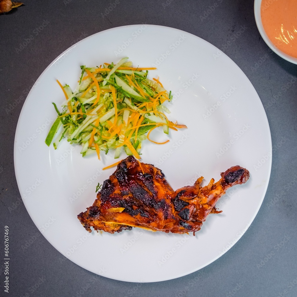 Wall mural Top view of crispy baked chicken drumsticks with salad on the white plate