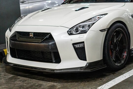 Closeup shot of the front of a white Nissan GT-R sportscar in a parking lot