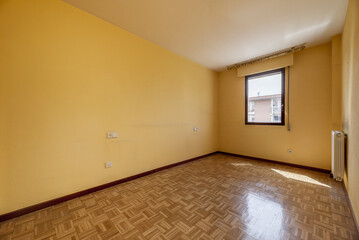 An empty living room with slatted oak parquet flooring