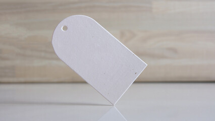 Blank price tag on wooden background. Eco friendly label tag concept.