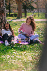 Fototapeta na wymiar School girls studying before exam in the park