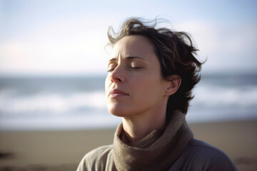 Portrait of a beautiful young woman with eyes closed on the beach
