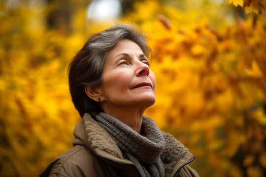 Portrait of a beautiful mature woman in the autumn park. Selective focus.