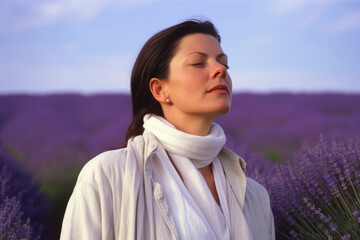 Young beautiful woman in lavender field at sunset. Girl with closed eyes