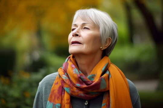 Medium shot portrait photography of a woman in her 60s practicing mindfulness sophrology relaxation & stress-reduction wearing a charming scarf against a garden or botanical background