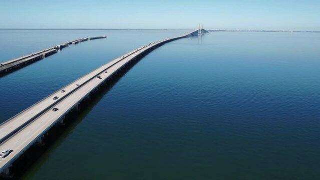 Drone time lapse footage over cars driving on long Seven Mile Bridge with blue sky on the horizon
