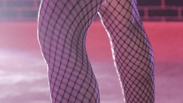 Sensual performance of female dancers in fishnet stockings closeup shot. Luxurious clothes and accessories for erotic stage