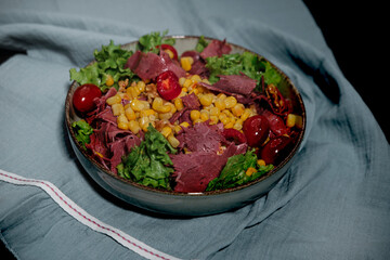 cold cut beef meat sliced in light summer salad with greens, lettuce, sweet corn, cherry tomatoes,...
