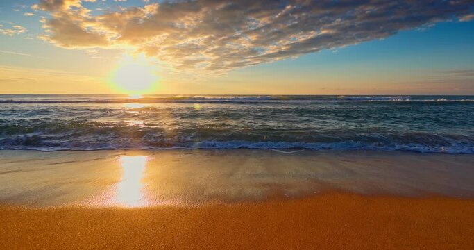 Color tropical ocean sunrise over beach sand and sea waves 4K video