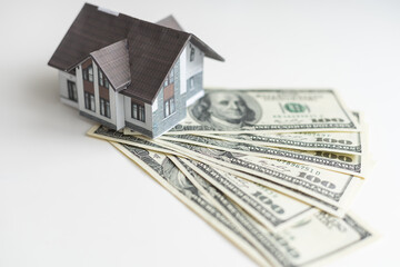 little house model with many dollar banknotes and keys. Real estate insurance. Investment