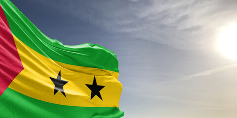 Sao Tome and Principe national flag cloth fabric waving on beautiful grey sky Background.