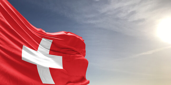 Switzerland national flag cloth fabric waving on beautiful grey sky Background. - Powered by Adobe