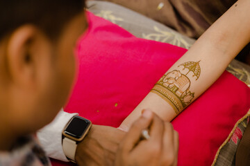 Artist applying henna tattoo on women . Mehndi is traditional Indian decorative art. Close-up