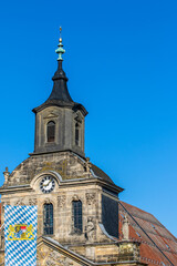 Fototapeta na wymiar Spitalkirche in Bayreuth mit Flagge Bayerns vor blauem Himmel