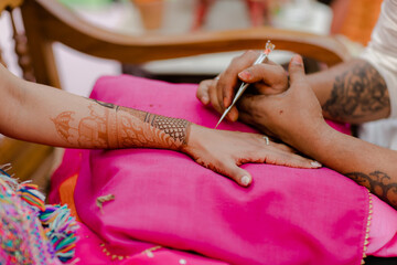 Artist applying henna tattoo on women . Mehndi is traditional Indian decorative art. Close-up