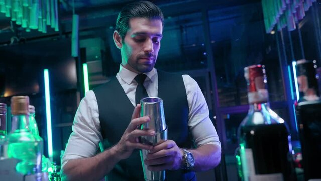 Professional bartender man shaking cocktail for guest in nightclub