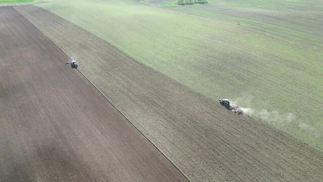 Traktoren pflügen ein Feld für die Aussaat im Frühjahr