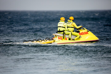 Rescuers on a yellow jet ski, lifeguards in action at sea