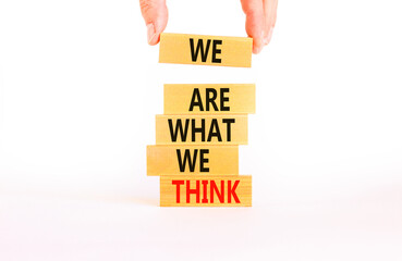 We are what we think symbol. Concept word We are what we think on wooden block. Beautiful white table white background. Businessman hand. Business We are what we think concept. Copy space.