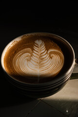 A cup of late' coffee with Rosetta pattern, warm color tone.