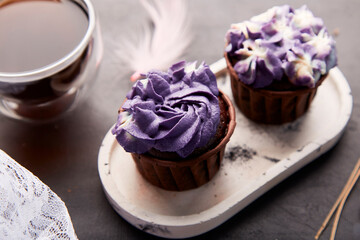 Purple aesthetics trendy floral cupcake and cup of coffee. French no sugar dessert close up