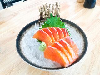 Salmon Sashimi., A famous Japanese menu is salmon sashimi., Salmon sashimi cutting fresh and raw pieces served on ice in a bowl.