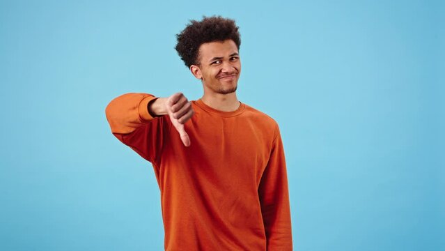 Young black man expresses disapproval showing thumbs down
