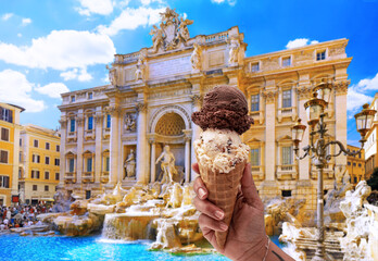 Tourist eats an ice cream in front of the Trevi Fountain in Rome.