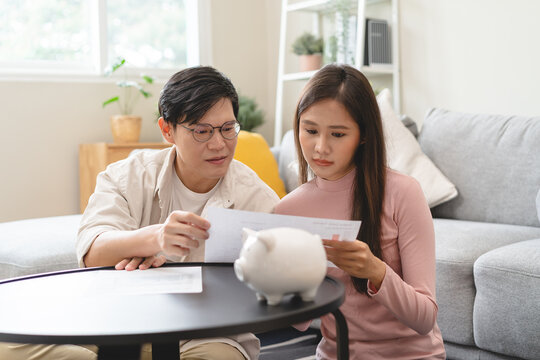 Happy Asian Family Young Couple Love Hand Holding Piggy Bank To Save And Model House For Saving Money Wealth To Buy Real Estate For New Home. Financial Planning, Business Finance Concept. Housing Loan